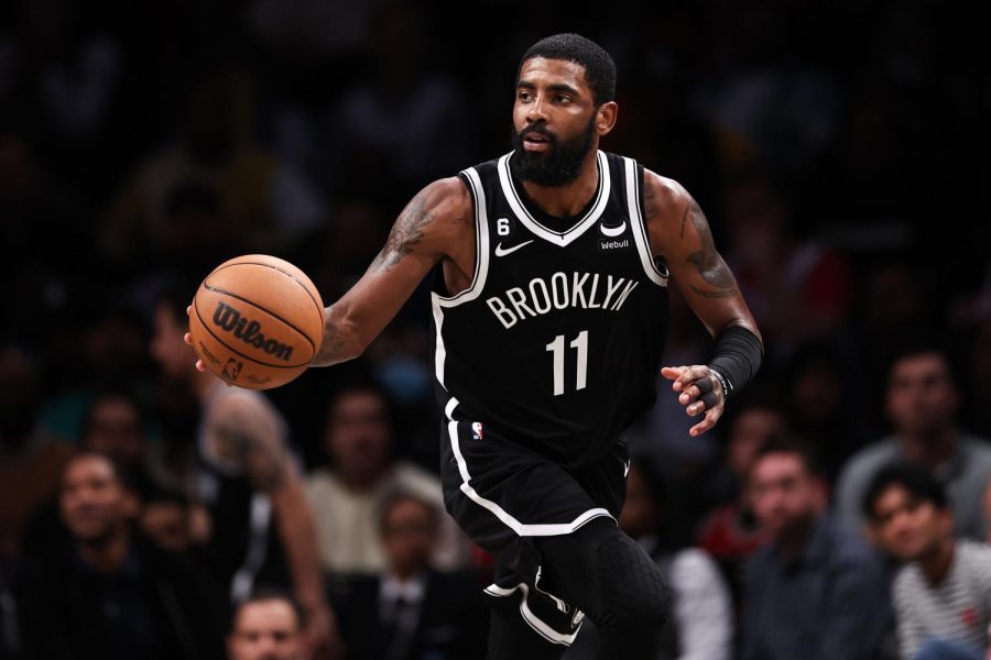 NBA star Kyrie Irving dribbles the ball on the court.