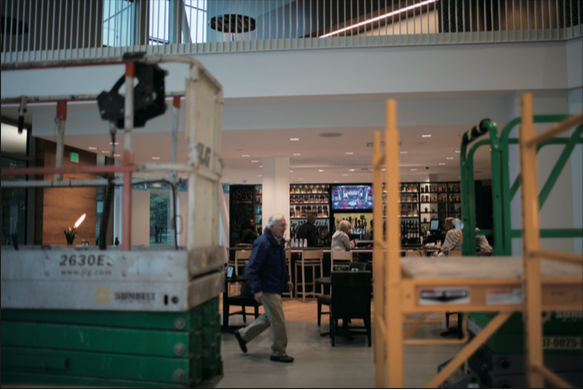 A visitor at The Hotel at Oberlin strolls past the bar. While construction continues on portions of the Peter B. Lewis Gateway Center, the hotel will host its first large conference Oct. 6–8 with participation from Arnold Schwarzenegger and famous environmentalist Bill McKibben.